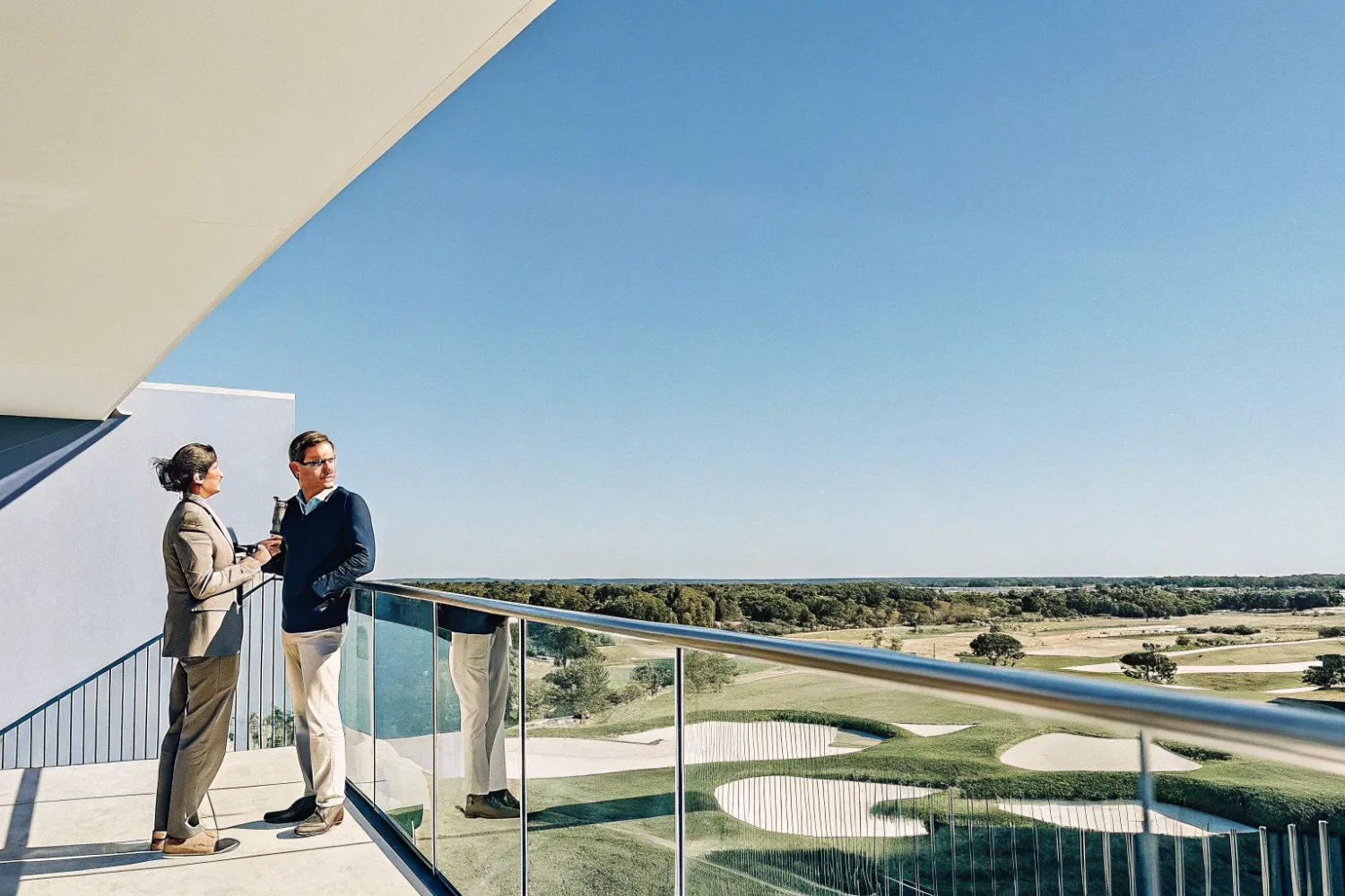 Scenic aerial view of a well-maintained golf course property with rolling fairways and greens under bright daylight