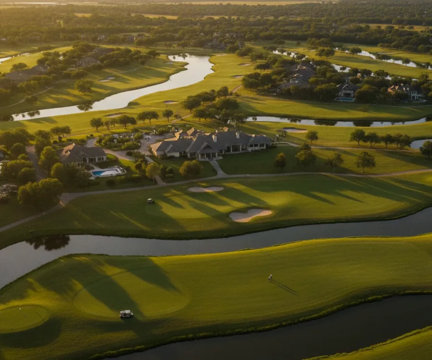 Aerial view of a scenic golf course property with rolling fairways and greens