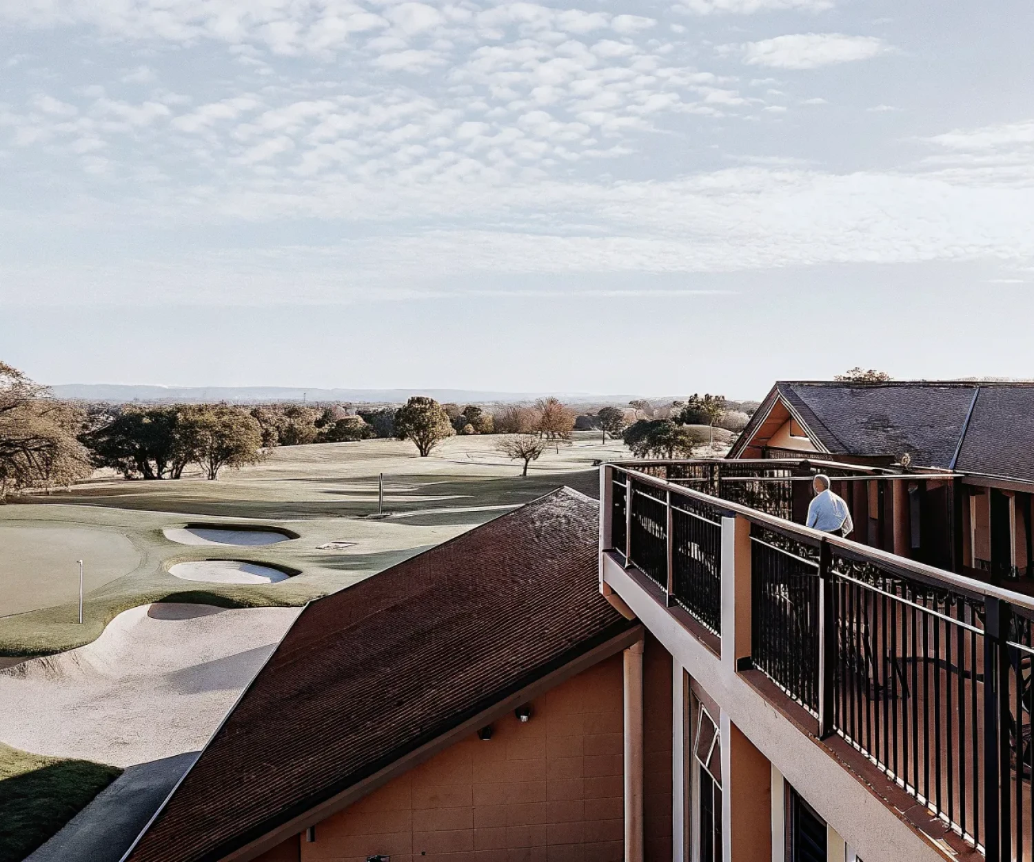 Aerial view of a golf course with fairways and greens on a sunny day